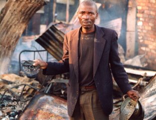 William Mauthu collects anything he can that survived the fire of July 15, even finding roof nails to try to rebuild his home